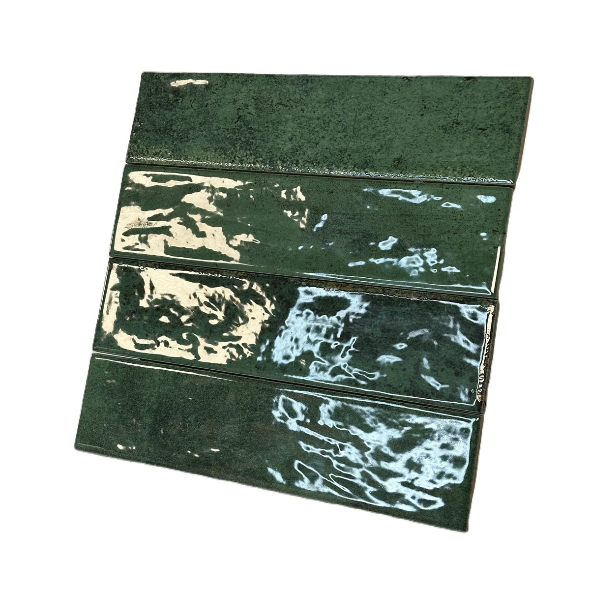 Vue inclinée de quatre carreaux Asly Green avec reflets sur la finition brillante effet zellige.